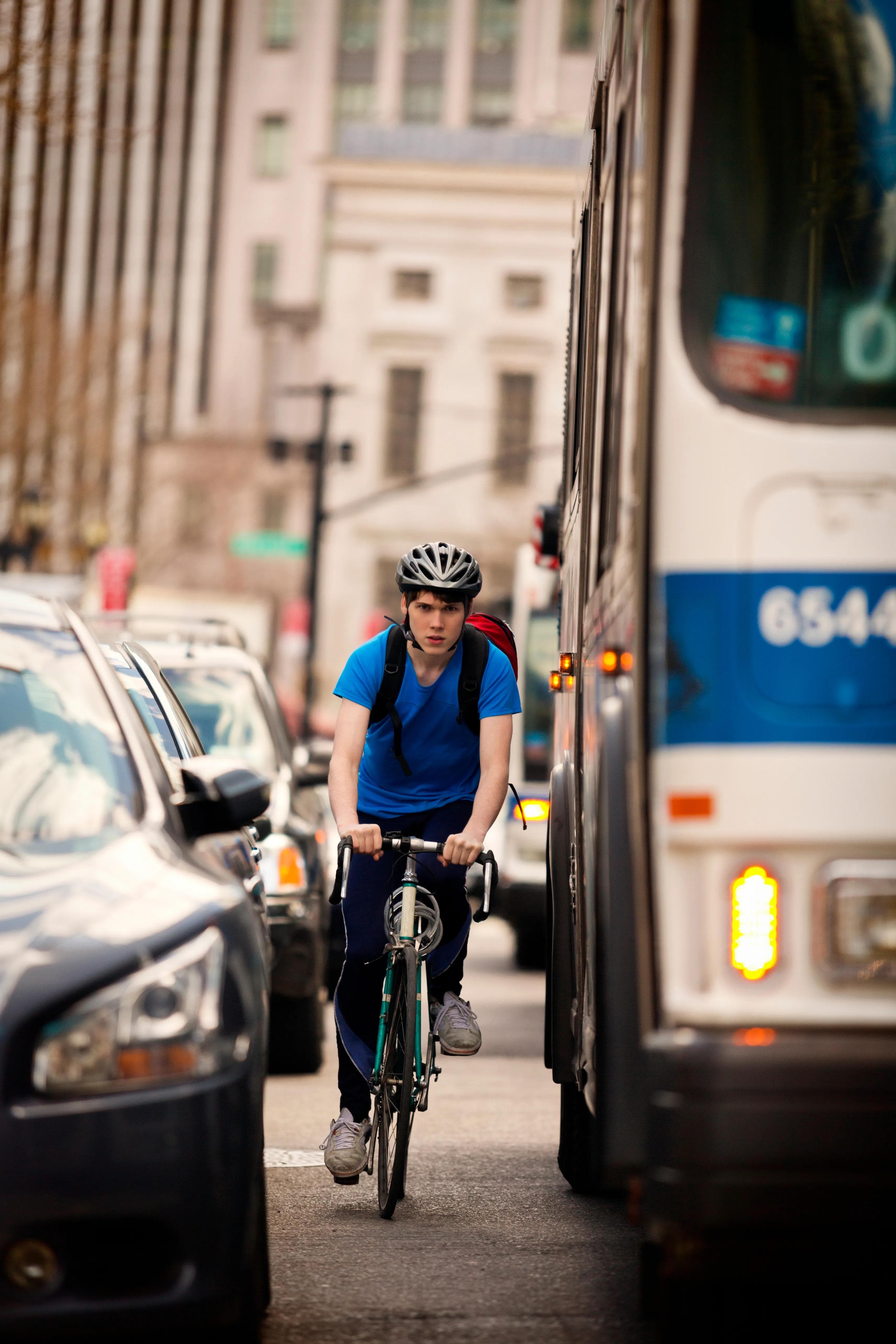 An nyc cyclist riding in the street between traffic